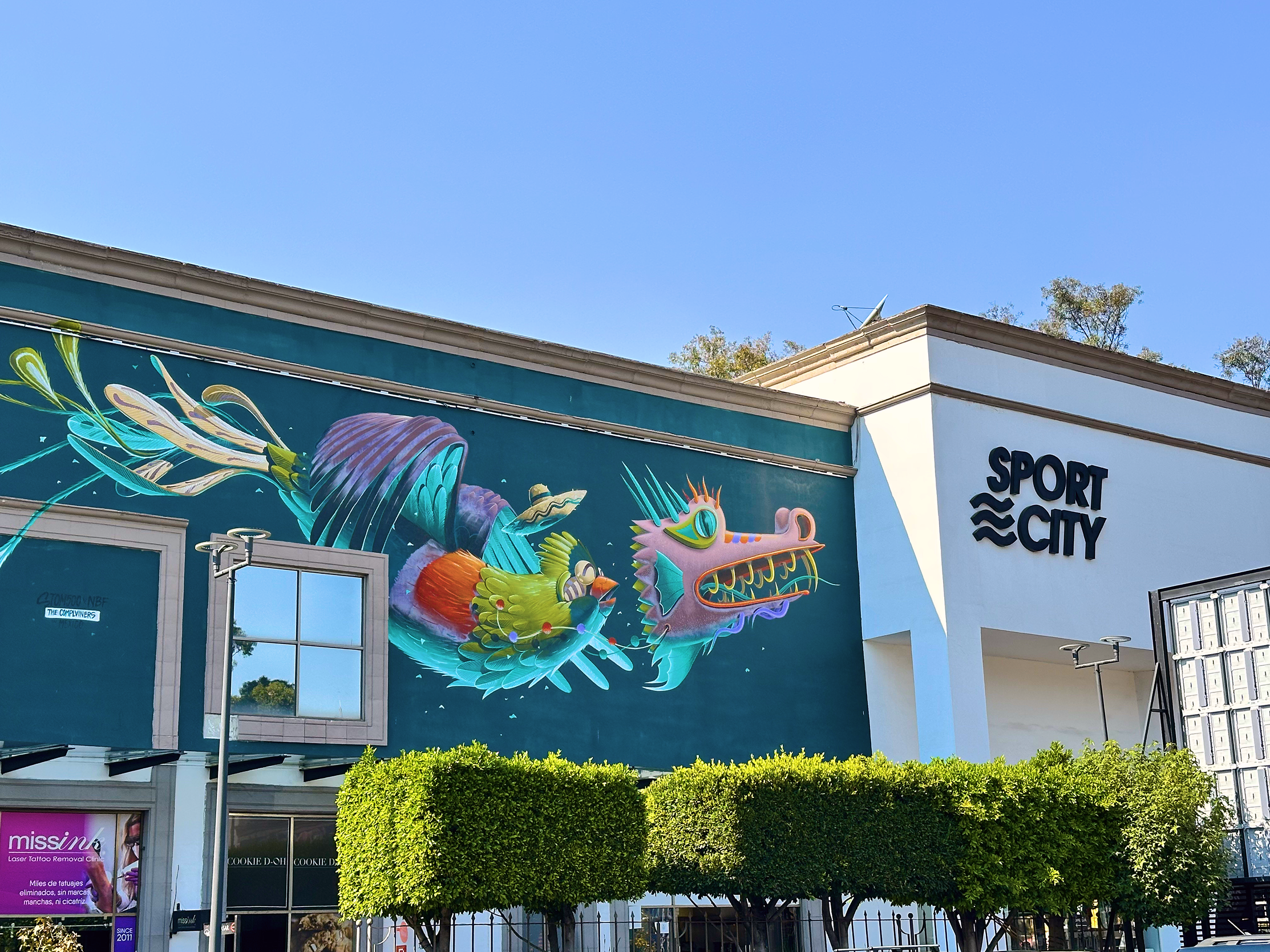 Mural de dragón alebrije sobre muro verde en Sport City Cielo Abierto