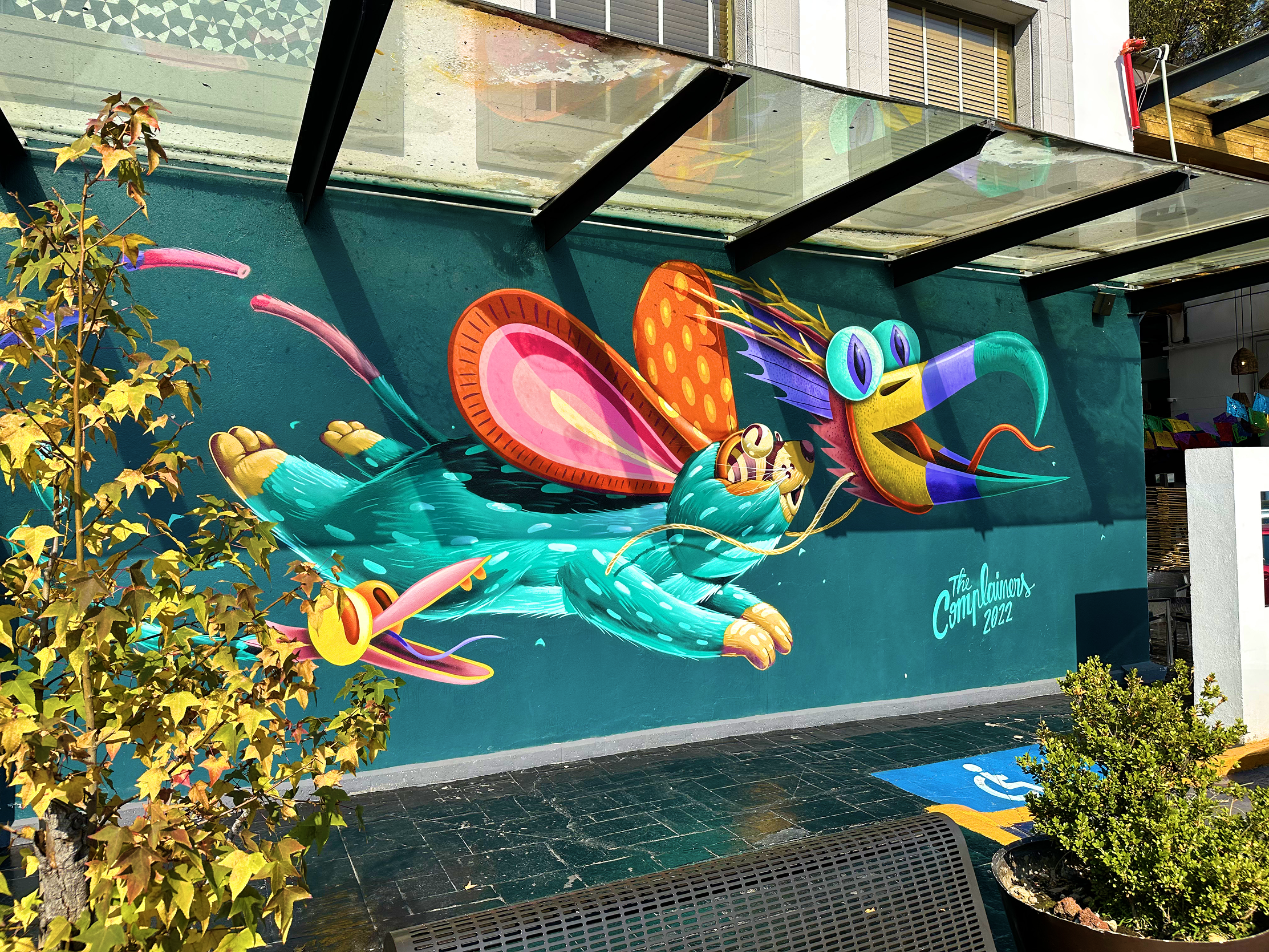 Graffiti vibrante de alebrije ratón cerca de cajeros