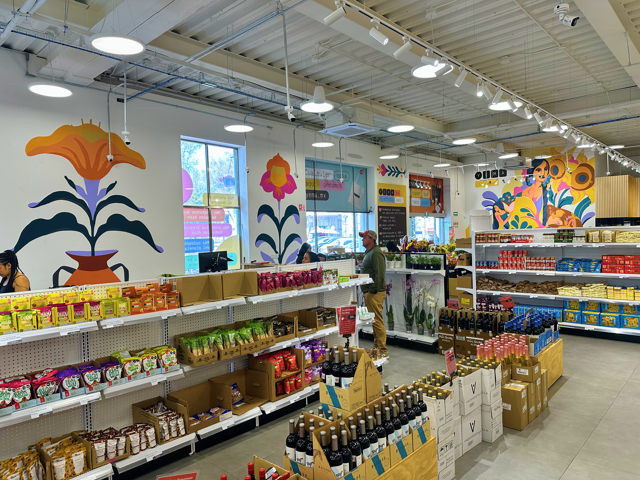 Columnas pintadas con flores en zona de cajas